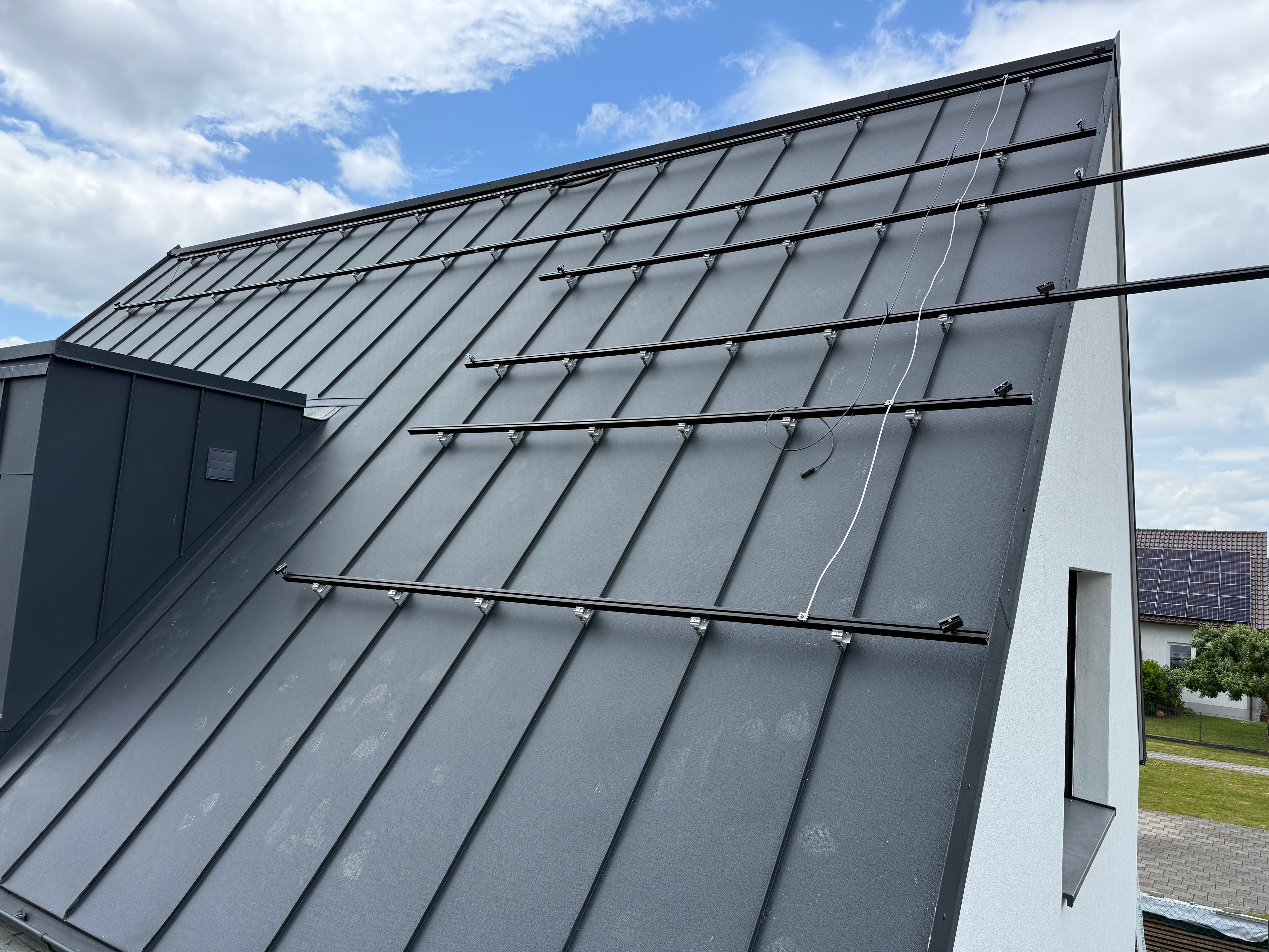 Schwarze Schienen auf einem Metalldach